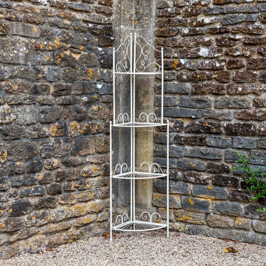 Blaisdon 4-tier corner shelf in cream in front of stone wall.