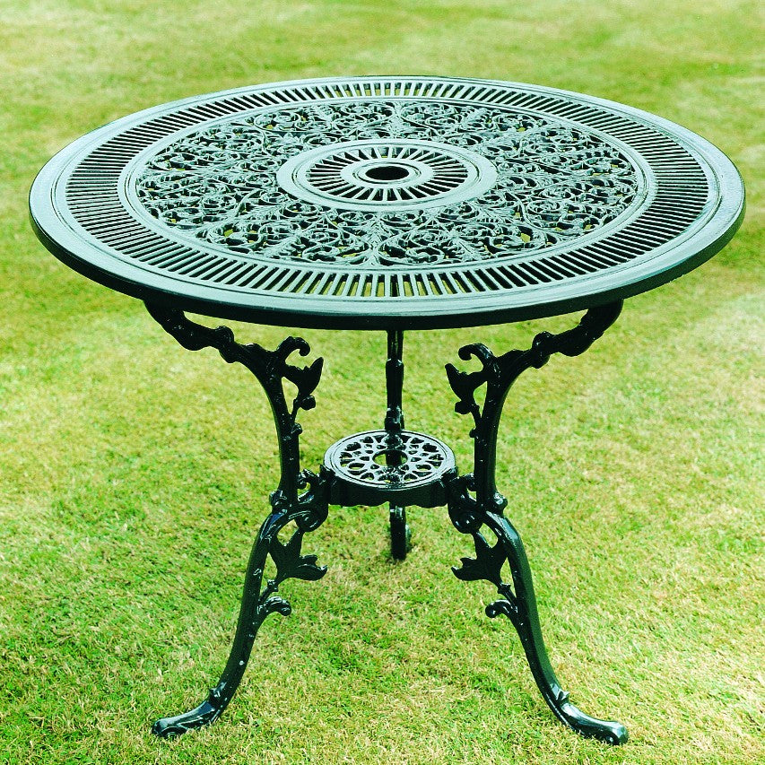 Jardine Leisure Coalbrookdale 81cm round table in green finish standing on lawn