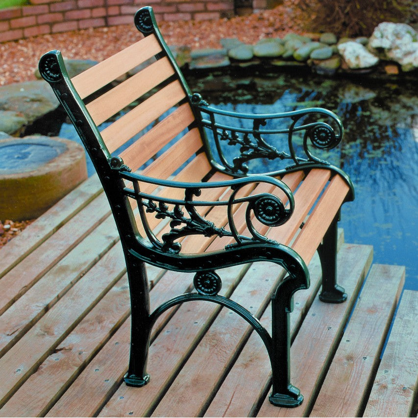Jardine Leisure Edwardian chair with iroko hardwood slats and green finish positioned on wooden decking next to pond