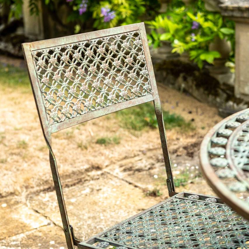 Close-up of the intricate lattice detail on an Ascalon Marlborough bistro chair in antique blue rust.