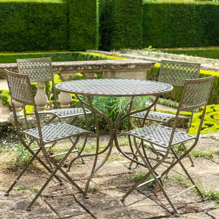 Ascalon Marlborough 5 piece bistro set in antique blue rust on patio with formal hedges in background.