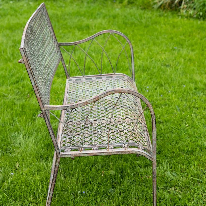 Side view of Marlborough bench in antique blue rust standing on grass.