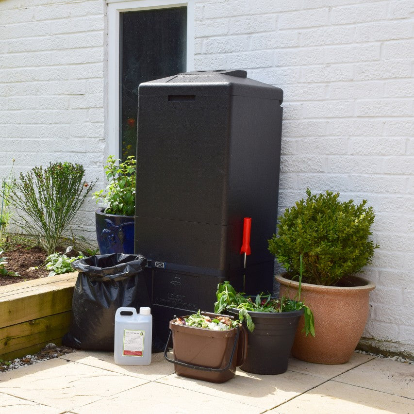 HOTBIN composter standing in corner of patio with kitchen and garden waste next to it ready to be recycled